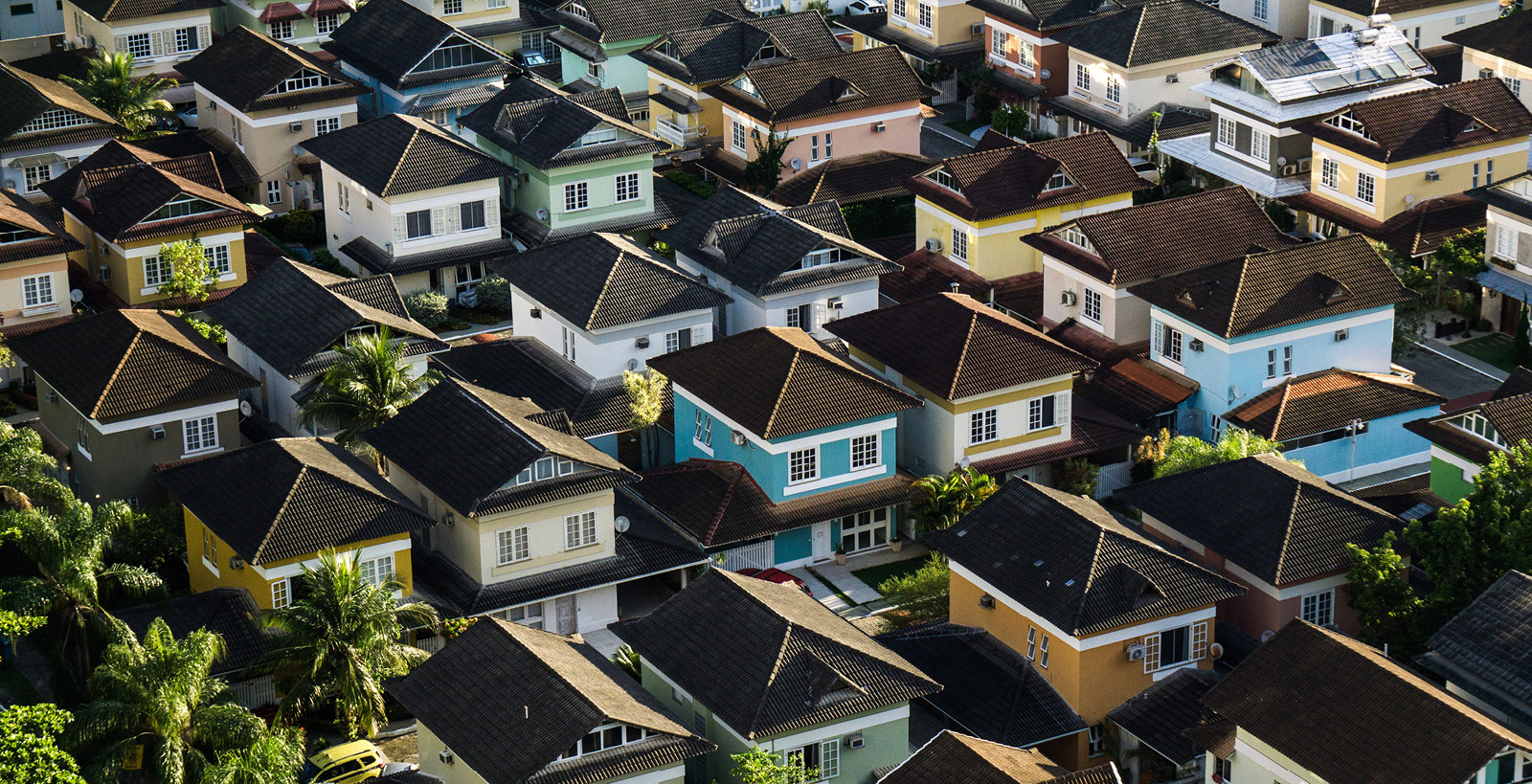 An aerial photo of a suburb of colorful, tightly-packed homes in a large suburb.