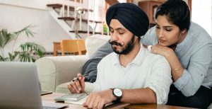 Man and woman assessing their taxes at a computer.