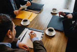 close up of meeting with three people at a conference table