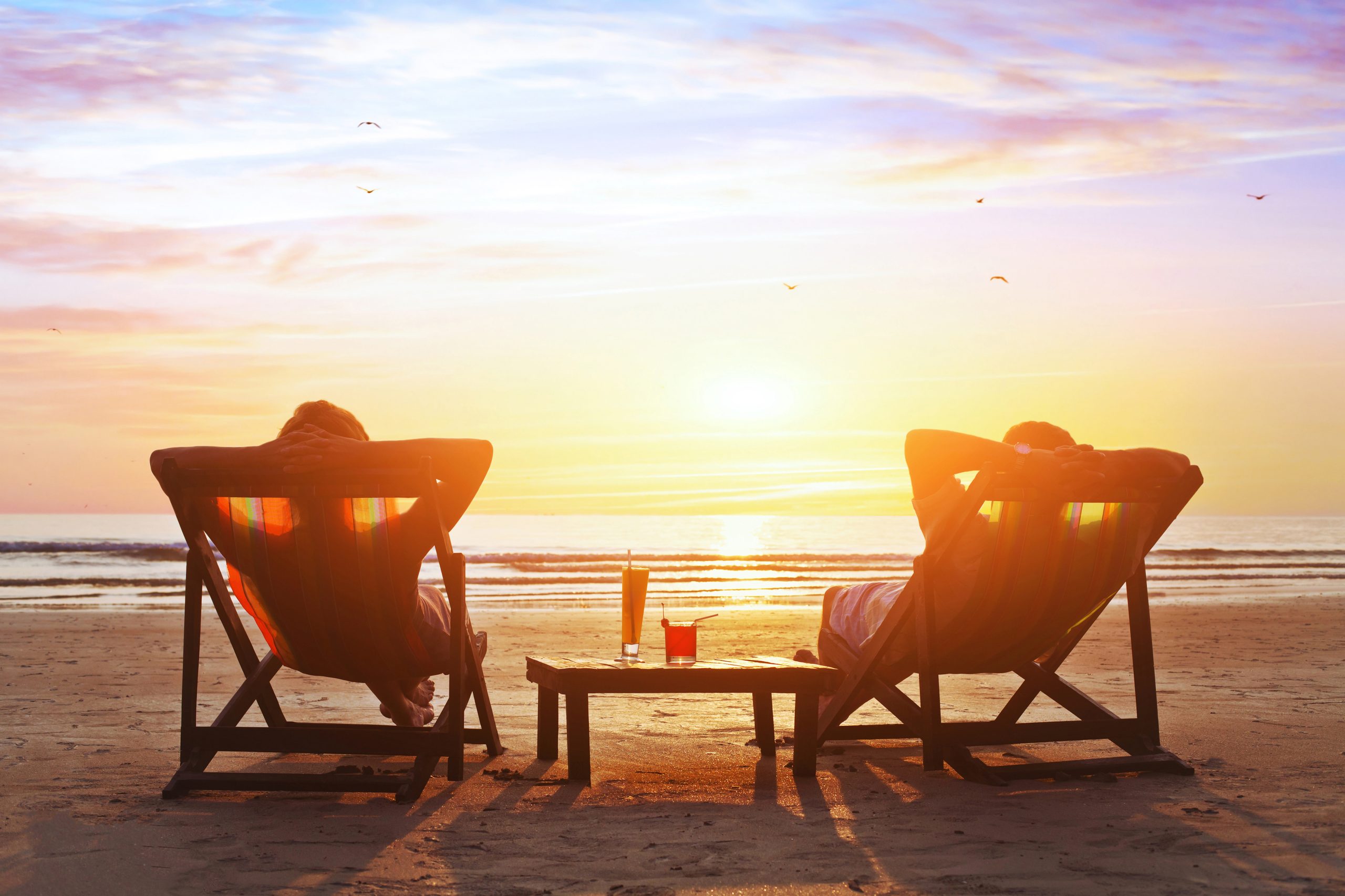 happy couple enjoying sunset on the beach
