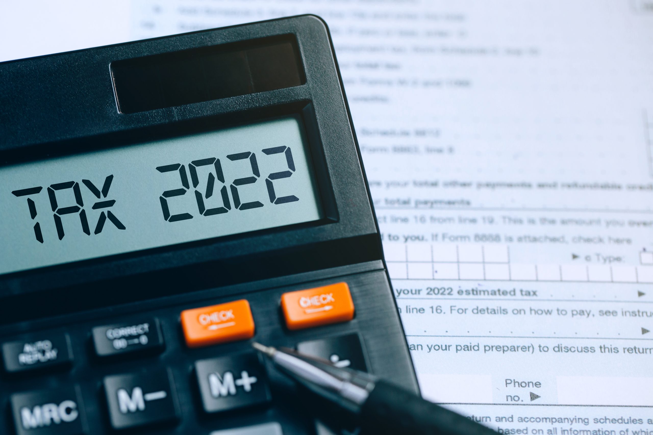 Word Tax 2022 on the calculator on documents.Income Statement. paying the tax rate. Taxation, taxes burden.Business and tax concept.