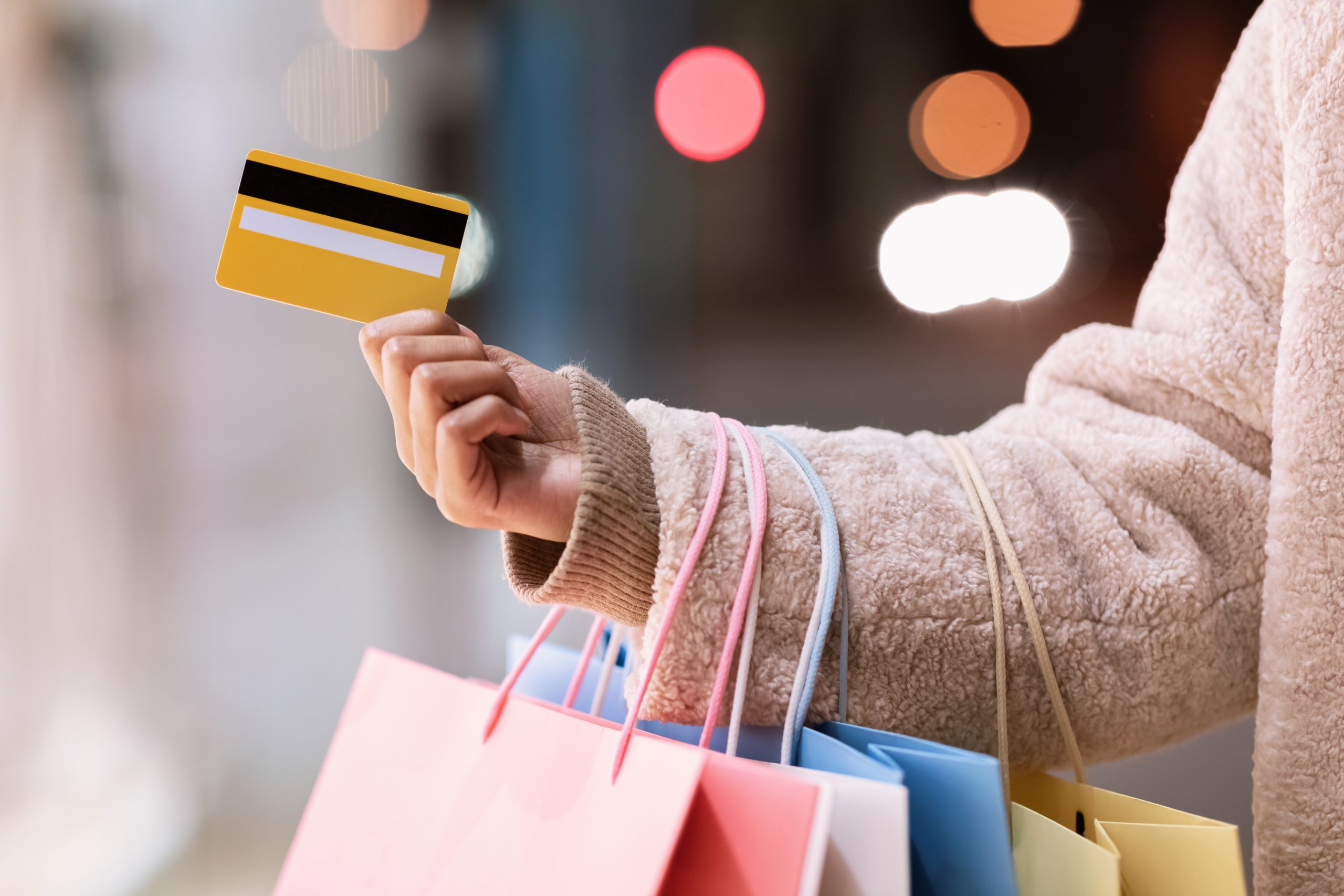 Cashback, Retail And Purchase, Seasonal Sales. Closeup Of Unrecognizable African American Young Lady Holding Debit Credit Card In Hand, Standing With Colorful Shopping Bags Outside Near Mall