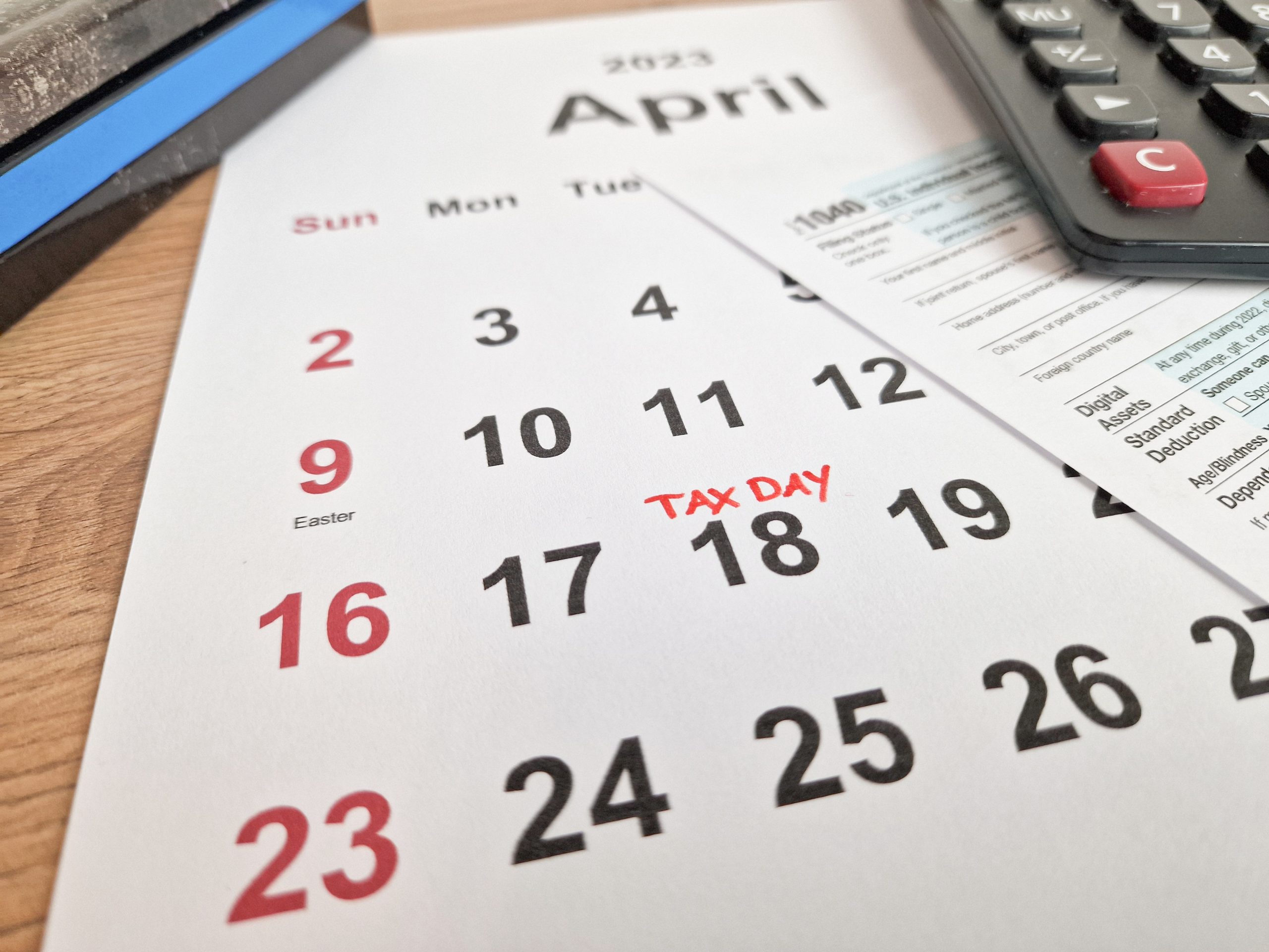 Tax payment day marked on a calendar - April 18, 2023 with 1040 form, financial concept