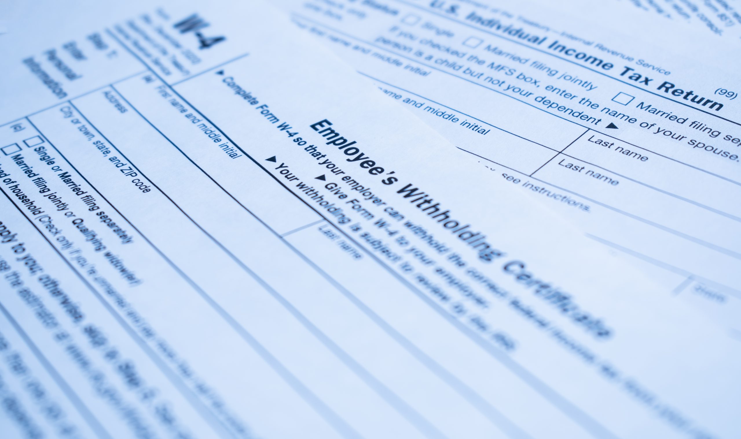 A closeup of the Form W-4, Employee's withholding certificate, and a fountain pen on a wooden surface