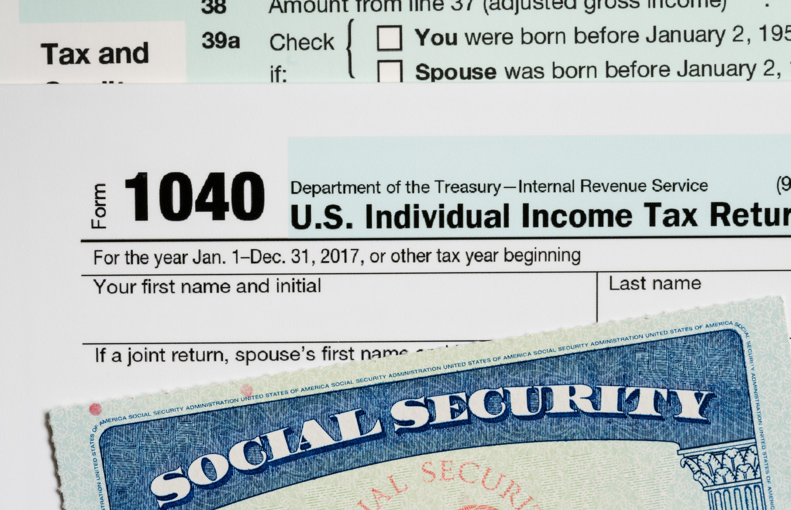 Social Security card in the USA laid on top of Form 1040 tax return of income in retirement